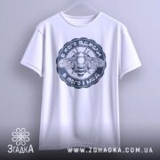 Футболка в кого бджоли, біла, підвішена на вішалці, фон світлий, принт з бджолою та написом у темно-синьому кольорі.