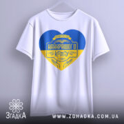 Футболка вчитель найкращого класу білого кольору, зображена з фронтального ракурсу, фон світло-сірий, принт у формі серця з жовто-блакитними кольорами та написом 'Вчитель найкращого класу у світі'.