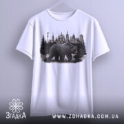 Футболка ведмідь Київ, біла, підвішена на вішалці, фон світло-сірий, принт з ведмедем на фоні київських будівель та лісу.