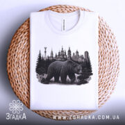 Футболка ведмідь Київ, біла, складена на кошику, фон світло-сірий, принт з ведмедем та архітектурою Києва.