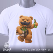 Футболка Ведмідь Пиво, складена футболка білого кольору, з принтом ведмедя з вусами, який тримає ящик з пляшками пива, на футболці є етикетка з логотипом, фон світло-сірий, деталі принта яскраві.