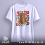 Футболка ведмідь у квітах, біла, підвішена на вішалці, фон світло-сірий, принт з ведмедем в оточенні червоних квітів та зеленого листя.