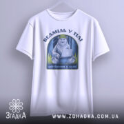 Футболка ведмідь у тілі, біла, підвішена на вішалці, фон світло-сірий, принт з ведмедем у зеленій шапці, що сидить за ноутбуком, текст під принтом - 'айтішник у душі'.