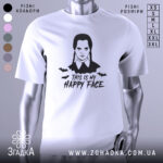 Футболка Венздей хеппі фейс білого кольору, зображена на манекені, з принтом у вигляді обличчя персонажа з косичками та написом 'THIS IS MY HAPPY FACE', фон світло-сірий, деталі принта включають летючих мишей.