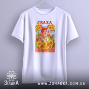 Футболка весела сваха, біла, підвішена на вішалці, фон світло-сірий, принт з жінкою в українському національному вбранні, оточена соняшниками, напис 'СВАХА' червоним кольором.