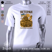 Футболка мужність України, біла, зображена з фронтального ракурсу, фон нейтральний, принт з чоловіком у військовій формі, що тримає прапор України, текст "ВЕТЕРАН" та "ПОВЕРНУВСЯ, ЩОБ ЖИТИ" вгорі та внизу принта.