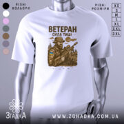 Футболка ветеран білого кольору, зображена на манекені, ракурс спереду, фон градієнтний сірий, принт з військовим, що тримає гвинтівку, з елементами природи та українським прапором на формі.