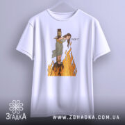 Футболка відьма на вогні, біла, підвішена на вішалці, фон світло-сірий, принт з відьмою, яка стоїть на вогняному стовпі, з написом 'FUCK IT'.