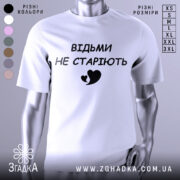Футболка відьми не старіють, білого кольору, зображена з фронтального ракурсу на манекені, фон світло-сірий, принт чорного кольору з написом 'ВІДЬМИ НЕ СТАРІЮТЬ' та малюнком серця.