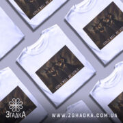 Футболка відьомський вайб, біла, зображена на манекені, фон сірий, принт з чотирма відьмами в чорних сукнях, текст 'GIRLS WILL BE GIRLS' під принтом.