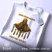 Футболка військовий стиль, біла, зображена зверху, складена, фон світло-сірий, принт з черепом у капюшоні та бомбами, текст 'DEATH FROM ABOVE' і 'FIRE FOR EFFECT' жовтого кольору, на футболці є етикетка.