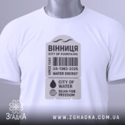 Футболка Вінниця місто фонтанів, біла, складена на поверхні, фон світло-сірий, принт у сірому кольорі з текстом "ВІННИЦЯ CITY OF FOUNTAINS" та етикетка з зеленим шнурком.