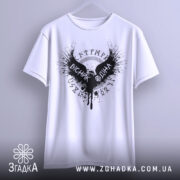 Футболка вісник одіна, біла, зображена з фронтального ракурсу, підвішена на вішалці, фон світло-сірий, принт чорного кольору з крилами та написом 'VІСНІК ОДІНА'.