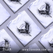 Футболка вісник одіна, біла, зображена з фронтального ракурсу, на манекені, фон світло-сірий, принт чорного кольору з крилами та написом 'VІСНІК ОДІНА'.