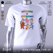 Футболка вітаємо в дурдомі, біла, зображена з близької відстані, на фоні світло-сірого кольору, принт з веселими персонажами: ведмедем, лисицею, зайцем та іншими тваринами, які танцюють, з написом 'ВІТАЄМО В ДУРДОМІ!!' у яскравих кольорах.