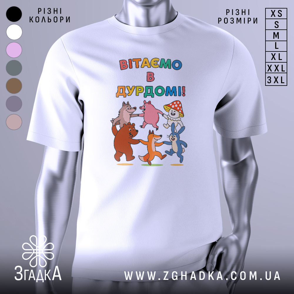 Футболка вітаємо в дурдомі, біла, зображена з близької відстані, на фоні світло-сірого кольору, принт з веселими персонажами: ведмедем, лисицею, зайцем та іншими тваринами, які танцюють, з написом 'ВІТАЄМО В ДУРДОМІ!!' у яскравих кольорах.