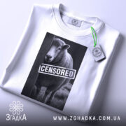 Футболка вівця цензоред, біла, зображена зверху, на фоні світлого градієнта, принт з овечкою та написом 'CENSORED', з зеленим ярликом.