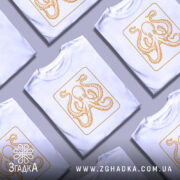 Футболка восьминіг у квадраті, біла, зображена на манекені, фон світло-сірий, принт з оранжевим восьминогом в квадраті.