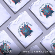 Футболка вовк інстинкти, біла футболка з принтом, зображення вовка в геометричному стилі, ракурс спереду, фон світло-сірий, принт містить текст 'ІНСТИНКТИ СИЛЬНІШІ ЗА ПРАВИЛА!' у кольорах червоного та синього.