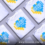 Футболка всесвіт у тобі, біла, зображена на манекені, фон світло-сірий, принт у формі серця з жовтими та блакитними квадратами, текст "ВСЕСВІТ у тобі" великими буквами.