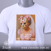 Футболка всі люди діляться, біла, зображена з верхнього ракурсу, на фоні світло-сірого градієнта, принт з дівчиною в рожевій сукні та масці, з червоними сердечками, підпис на принті: 'всі люди діляться на дві частини', з етикеткою на рукаві.