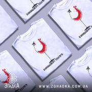 Футболка винищувач сухого білого кольору, зображена на манекені з правого ракурсу, фон нейтральний, принт з червоним курчам у келиху та літаком, текст під принтом чорного кольору.