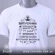 Футболка випускник кращої школи, білого кольору, зображена зверху, на плоскій поверхні, фон світло-сірий, принт чорного кольору з написом та елементами декору, на комірці видна етикетка.