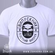 Футболка випускник витримка, біла, складена на поверхні, фон світло-сірий, принт чорного кольору з написом 'ВИПУСКНИК' та зображенням диплома, на футболці є етикетка з зеленим шнурком.