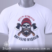 Футболка вирубую мудаків, білого кольору, зображена в горизонтальному положенні, фон світло-сірий, принт з черепом, бородою та сокирами, на комірці є етикетка.