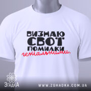 Футболка визнаю свої помилки, білого кольору, складена на плоскій поверхні, фон світло-сірий, принт чорного кольору з червоним акцентом, текст розташований по центру, на комірці видна етикетка.