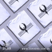 Футболка з феніксом білого кольору, зображена на манекені, фон світло-сірий, принт чорного кольору з феніксом та геометричними елементами на грудях.