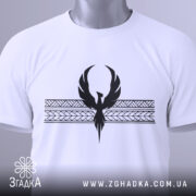 Футболка з феніксом білого кольору, складена на поверхні, фон світло-сірий, принт чорного кольору з феніксом та геометричними елементами, на комірці видна етикетка.