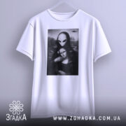 Футболка з Моною Лізою, білого кольору, підвішена на вішалці, фон світло-сірий, принт зображає Мону Лізу з інопланетянином, деталі принта чіткі, з елементами чорного і сірого.