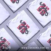 Футболка з отруйною змією, білого кольору, зображена з близького ракурсу на манекені, фон світлий, принт з чорної змії, що обвивається навколо червоного тексту 'VENOMOUS KEEP AWAY'.