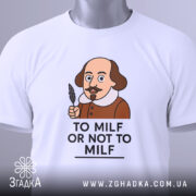 Футболка з шекспіром, білого кольору, зображена зверху, на столі, фон світлий, принт з карикатурним зображенням Шекспіра з пером в руці та написом 'TO MILF OR NOT TO MILF', на футболці є етикетка з зеленим шнурком.