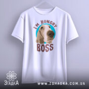 Футболка з собакою, білого кольору, підвішена на вішалці, фон світло-сірий, принт з собакою та написом 'I'M HUNGRY BOSS' чітко видимий.