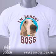 Футболка з собакою, білого кольору, складена на поверхні, фон світло-сірий, принт з собакою та написом 'I'M HUNGRY BOSS' розташований по центру, з зеленим ярликом.
