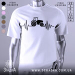 Футболка з трактором білого кольору, зображена з близького ракурсу, на фоні світло-сірого градієнта, принт з трактором та лінією, що нагадує кардіограму, виконаний в чорному кольорі.