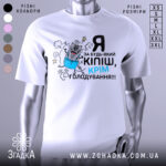 Футболка за будь-який кіпіш, біла, зображена з фронтального ракурсу на манекені, фон нейтральний, принт з веселим котом у синіх штанах, текст чорний і блакитний.