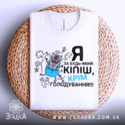 Футболка за будь-який кіпіш, біла, зображена зверху на плетеній основі, принт з котом у синіх штанах, текст чорний і блакитний.