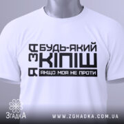 Футболка за кіпіш: біла футболка, складена на поверхні, з чорним принтом, що містить текст "Будь-який з Кіпіш, якщо моя не проти", вид зверху, фон світло-сірий.