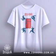 Футболка забіг до холодильника. Біла футболка підвішена на вішалці, з принтом червоного холодильника та стрибаючими фігурами. Ракурс спереду, фон світлий, деталі принта в темно-синьому кольорі, час вказано як 21:00.