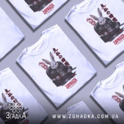 Футболка заяча мафія, біла, зображена з фронтального ракурсу на манекені, фон нейтральний, принт з зображенням кролика в чорному костюмі з мечем, текст на принті японською мовою та написом 'ZAYKUZA'.