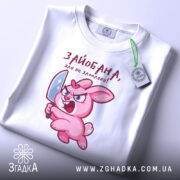 Футболка зайобана але не зломлена, біла, складена на поверхні, фон світло-сірий, принт з рожевим зайцем, що тримає ніж, з виразом гніву, з етикеткою на шнурку.