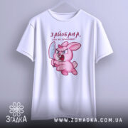 Футболка зайобана але не зломлена, біла, зображена на манекені, фон світло-сірий, принт з рожевим зайцем, що тримає ніж, з виразом гніву, рукави короткі.