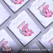 Футболка зайобана але не зломлена, біла, зображена на манекені, фон світло-сірий, принт з рожевим зайцем, що тримає ніж, з виразом гніву.