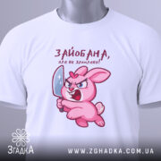 Футболка зайобана але не зломлена, біла, складена на поверхні, фон світло-сірий, принт з рожевим зайцем, що тримає ніж, з виразом гніву, з етикеткою на шнурку.