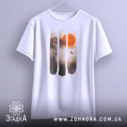 Футболка захід сонця, біла, підвішена на вішалці, фон світло-сірий, принт з червоним сонцем та лісом в тумані, деталі принта чіткі та яскраві.