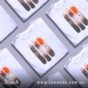 Футболка захід сонця, біла, зображена на манекені, фон нейтральний, принт з червоним сонцем та лісом в тумані, деталі принта виконані в м'яких коричневих тонах.