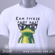 Футболка жаба кам тугезе, біла, складена на поверхні, фон світлий, принт з жабою в окулярах, текст "Кам тугезе райт нау!" над жабою, на футболці є етикетка.